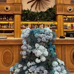 A simple color palette can make a powerful statement. We created this stunning, cascading floral installation for a bar using various shades of blue hydrangeas, transforming the wooden bar into a work of art.