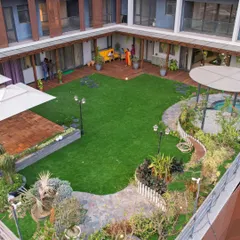 This high-angle shot reveals the scale of a courtyard garden we designed. The space is zoned with a large central lawn, multiple decked seating areas, and a gazebo, creating a multi-functional outdoor area for a large family.