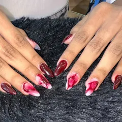 A striking design that looks like red smoke captured in a nail. I used a blooming technique with red and white polish on a stiletto nail shape to create this unique, marble-like effect.
