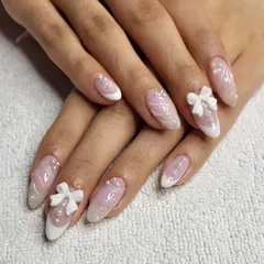 I love bringing Korean nail trends to my studio. This set features a soft pink base with a marble effect, delicate French tips, and is adorned with hand-sculpted 3D bows and pearls for a look that is both sweet and incredibly chic.