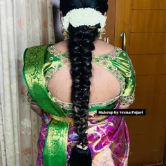 A classic, thick bridal braid adorned with delicate pearl pins. This is a timeless and elegant hairstyle that perfectly complements a traditional South Indian silk saree.