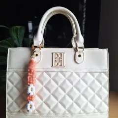A closer look at our daisy bag charm in a warm peach tone. Each flower is carefully knotted to create a cheerful and durable accessory.