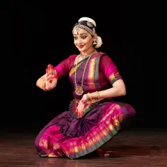 A seated pose expressing the anticipation and hope of the Nayika. The subtle smile and focused gaze are part of the intricate abhinaya used to tell her story.