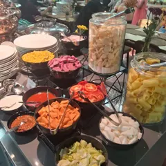 A do-it-yourself pasta and salad bar. This setup allows guests to create their own meal with a variety of fresh vegetables, cheeses, pasta, and sauces.