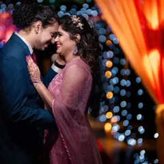 As the sun sets, the party begins. We specialize in reception photography, using creative lighting to capture the romance and energy, like this beautiful dance floor moment with a sparkling bokeh background.