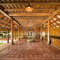 A look inside the Aranmula Palace, our reception area. The intricate woodwork, traditional terracotta floor tiles, and open-air design are hallmarks of classic Kerala architecture, creating a space that is both grand and grounding.