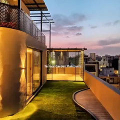 This rooftop design combines lush artificial grass with a curved wooden walkway, leading to a seating area. The combination of textures creates visual interest and defines the different zones of the terrace.