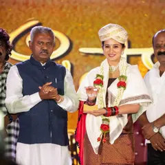 Actress Harshika Poonacha receiving an award on stage. We focus on capturing the expressions of honorees and presenters, providing our clients with memorable images from their corporate functions.