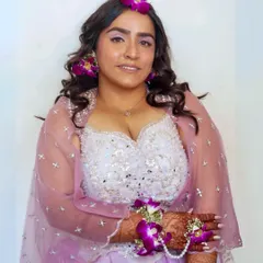 A full-length view of the bride's Haldi outfit. The makeup is kept fresh and radiant to complement the light, airy feel of her lehenga and the natural floral accessories.