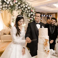 The happy couple cutting their beautiful multi-tiered wedding cake at the reception.