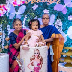 A precious multi-generational photo of a baby girl with her grandmothers at her first birthday party. Capturing the love between generations is a key part of our family event photography.