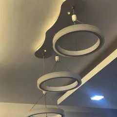This modern pendant light fixture features three suspended rings of varying sizes. It serves as a stylish centerpiece for a living or dining room, providing excellent illumination.