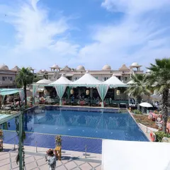 Another view of the poolside setup, showing the large-scale tents and aqua-colored drapes that provided shade and style.