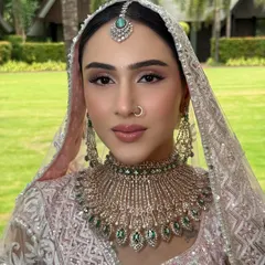 A closer view of her Anand Karaj makeup. We used soft brown and pink shades on the eyes and a natural pink lip to create a look that was both elegant and fresh. The sleek hair and emerald-drop maang tikka complete the look.