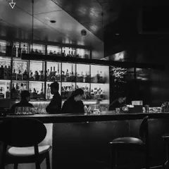 Our bar is a haven of monochromatic reflections and complex blended notes. It's where our skilled bartenders practice their craft, surrounded by a library of world-class spirits.