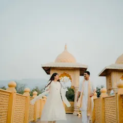 Walking together into their fairytale. This candid shot on a palace walkway captures the joy and effortless grace of the couple, with the architecture adding a touch of grandeur.