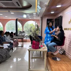 My studio is designed for learning. Here, I'm demonstrating an eye makeup look on a model, while students observe and take notes before their own hands-on practice session.