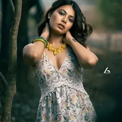 This is a classic outdoor portrait, where the shallow depth of field blurs the background and brings all the attention to the subject. The model's pose and direct gaze create a strong connection with the viewer, making it an impactful shot for a portfolio.