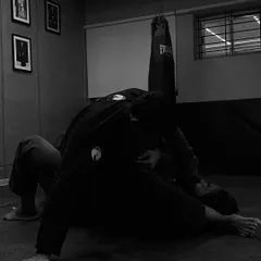 In the quiet moments of a roll, you are playing, learning, and working all at once. This black and white shot captures the intense focus of a Gi training session, where every grip and movement matters.