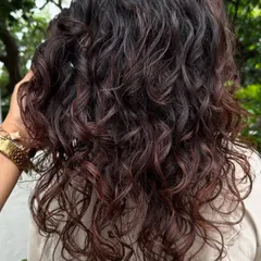 Curly and proud. I gave her curls a new life with a fresh cut, including a fringe, and subtle reddish-brown highlights to define the texture. Embracing your natural curls is always a good idea.