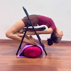 I demonstrate a deep backbend, Kapotasana, using a chair for support. Props are not shortcuts; they are tools for intelligence. They allow every student, regardless of stiffness, to safely explore the full depth of an asana, opening the thoracic spine and cultivating a state of courage and receptivity.