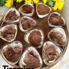 A tray of my classic Tiramisu cups, dusted with cocoa powder. I layer coffee-soaked ladyfingers with creamy mascarpone for an authentic Italian dessert experience.