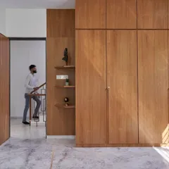 This minimalist floor-to-ceiling wardrobe in a light wood finish offers a clean and seamless look. The simple design conceals a wealth of storage, keeping the bedroom feeling uncluttered and serene.