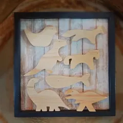 A framed collection of our wooden animal cutouts, including dinosaurs, a whale, and a bird. These are the blank canvases included in our DIY kits for kids.
