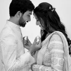 A classic black and white engagement photo, with the couple holding up their rings. This timeless style focuses purely on the emotion and the symbol of their commitment.