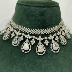 A close-up of an American diamond choker with teardrop pendants. The intricate design sparkles from every angle, making it a perfect rental for a night event.