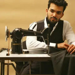A narrative-driven image showing the model at a sewing machine, as if in the process of creation. This behind-the-scenes style shot is effective for brand storytelling campaigns.