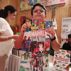 This young superhero fan found his treasure! A student proudly holds up the "Marvel Year by Year" visual history book he discovered at our school book fair stall.