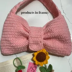 A flat lay of some of my favorite products. You can see my pink crochet bow bag, a sunflower pot, and a strawberry bookmark, showing the range of items I can create.