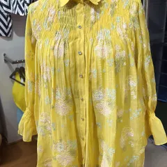 Perfect for a brunch outing, this yellow Chanderi shirt features beautiful floral embroidery and a smocked yoke. The scalloped collar and delicate buttons add to its charm.