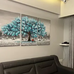 The blue tree canvas art installed in a client's home, perfectly matching their modern decor.