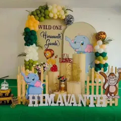 A "Wild One" jungle theme is one of our specialties. This setup for Himavanth's first birthday features cute animal cutouts, a lush green color palette, and a custom backdrop for a fun-filled celebration.