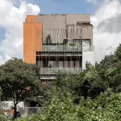 This is our 'Triode' multi-family residence, where we explored how to create privacy and community simultaneously. The custom louver system on the facade balances light and shade, connecting the apartments to the surrounding greenery while maintaining a sense of personal space for each family.
