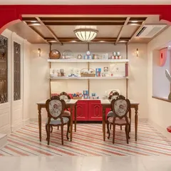 For the Parsi Dairy Farm renovation, I wanted to create a space that felt familiar yet fresh. This gifting zone, with its custom red cabinetry and floral upholstered chairs, is a cozy corner where customers can assemble hampers or enjoy a treat. It’s a perfect example of blending charming, old-world features with a clean, modern aesthetic.
