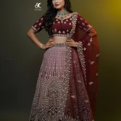 This heavily embroidered maroon lehenga is a masterpiece of craftsmanship. The detailed thread work across the skirt and blouse makes it a luxurious choice for a bride looking for a rich, non-traditional color for her wedding day.