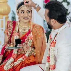 A close-up of the groom applying sindoor to the bride's forehead during their wedding in Vietnam, a deeply significant and beautiful Hindu ritual.