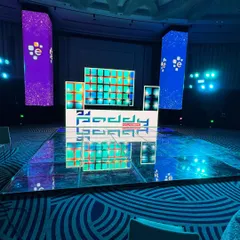 A wide view of the setup for a corporate gig. The combination of a custom DJ booth, LED video pillars, and a reflective dance floor transforms the ballroom into a high-energy party zone.