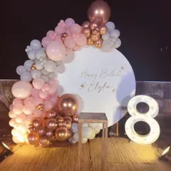 An elegant terrace party decoration for an 8th birthday. I used a circular backdrop and a pastel pink and rose gold balloon garland.