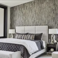 A modern bedroom featuring Phillip Jeffries’ authentic wood veneer wallcovering, "Sculpted Wood." The vertical grain and varied tones of the wood add natural warmth and sophisticated texture, creating a serene and stylish retreat.