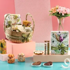 A showcase of our diverse packaging options, including a woven basket and gift box with matching floral prints. The arrangement demonstrates how we combine different elements like gourmet treats and decorative items into one cohesive, luxurious hamper.