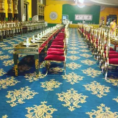This is our full seated dining setup for a large wedding ceremony. The long tables, elegant red and gold chairs, and individual brass thali settings ensure every guest feels like royalty.
