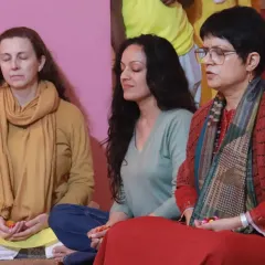 Students sit in quiet contemplation during a festival puja. These gatherings are a time for the community to come together, reflect, and absorb the spiritual vibrations of the ceremony.