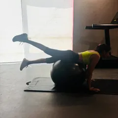 This exercise on the stability ball involves a single leg lift from a prone position. It's excellent for strengthening the glutes and hamstrings while simultaneously engaging the core to prevent the ball from rolling.