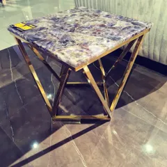 For a truly unique statement, we offer tables with semi-precious stone tops. This corner table features a stunning amethyst top set on a gold-finished geometric base, turning a functional piece into a work of art.