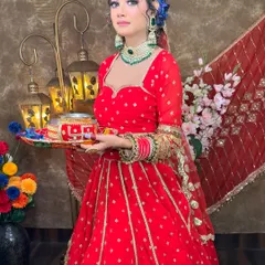 A full-length view of the red lehenga, showing its beautiful flare and gold detailing. It's a perfect outfit for looking your best during the evening puja.