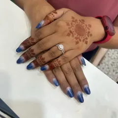 Another view of the blue and silver glitter ombre nails. The gradient effect is created by carefully blending the polishes to ensure a smooth transition from silver to deep blue.